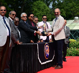 Steward of Mysore Race Club H K Ramesh presenting the Royal Western India Turf Club Ltd Trophy to trainer Faraz Arshad after his ward Southern Force won this event at Mysore on Sunday.